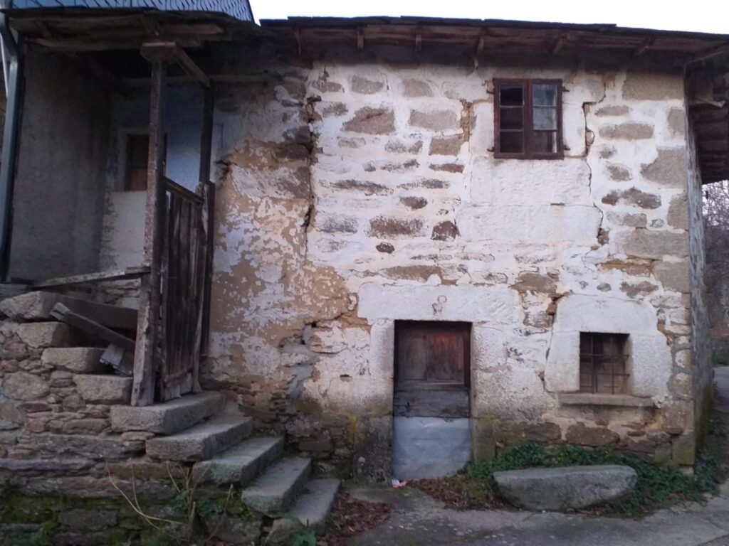 Antigua casa de piedra con escalera exterior en Galende